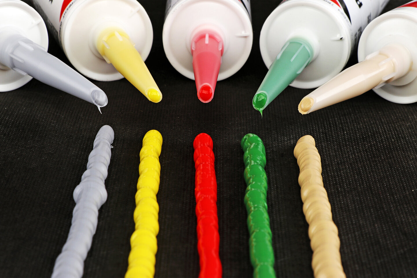 Cinq bandes de silicone côte à côte dans les couleurs gris, jaune, rouge, vert et beige.