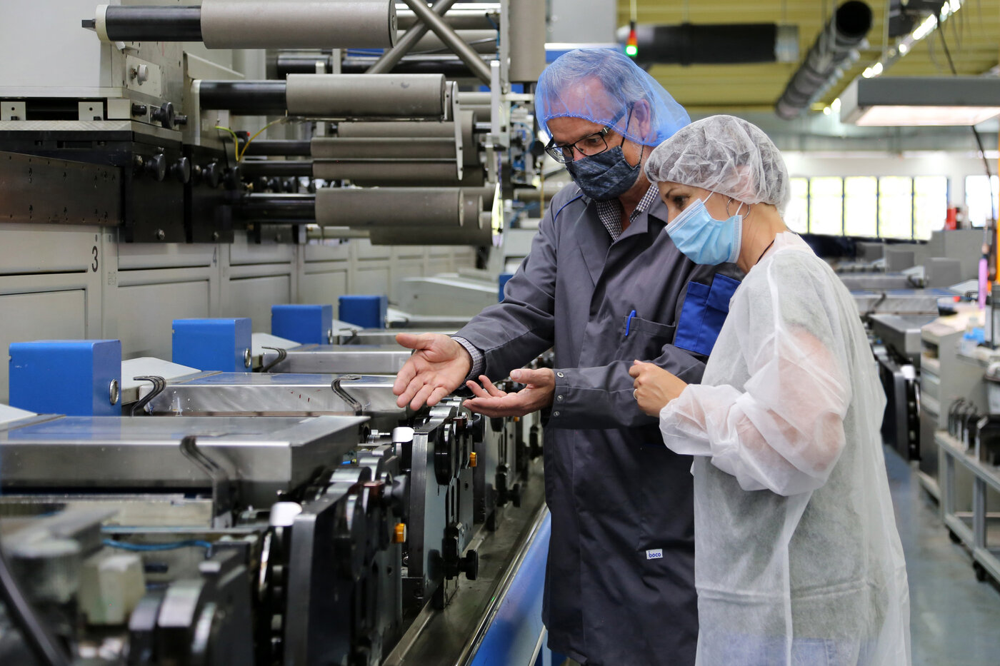 Permapack-Mitarbeiter mit Kundin bei der Druckabnahme in der Produktion