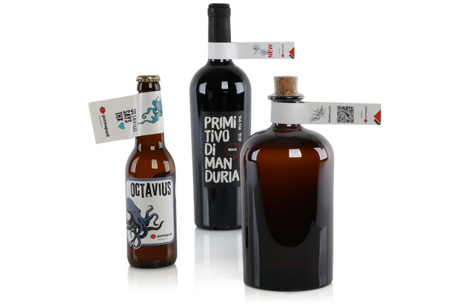 Une bouteille de vin, une bouteille de gin et une bouteille de bière portent chacune une étiquette en forme de boucle autour du cou.