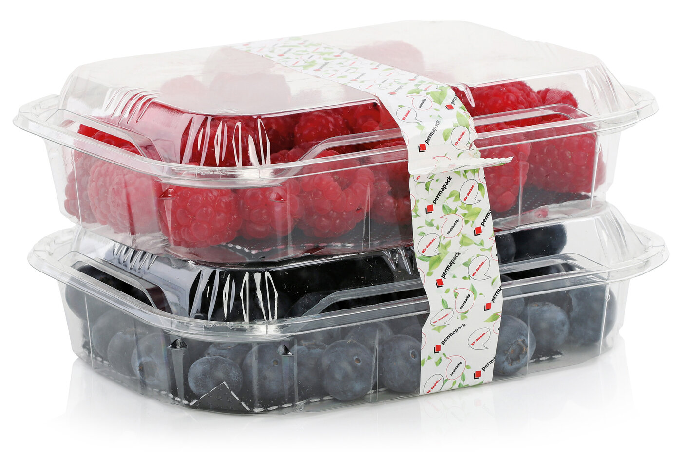 Deux barquettes couvertes transparentes avec des framboises et des myrtilles, enveloppées d'une étiquette sans fin durable pour l'industrie alimentaire. 