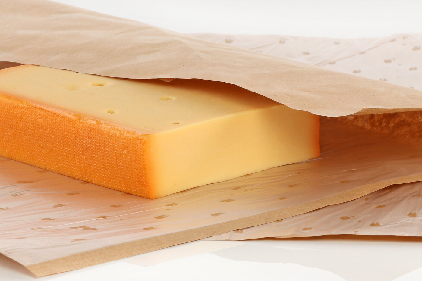 Un morceau de fromage est enveloppé dans un papier d'emballage séparable.