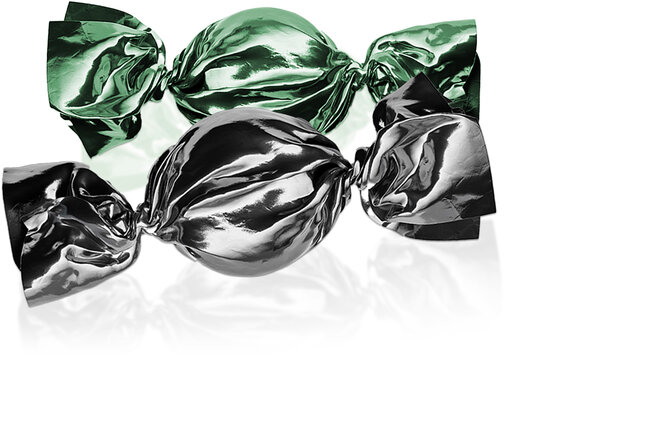 Deux bonbons, le bonbon de devant a un emballage noir. Celui de derrière a un emballage vert. 