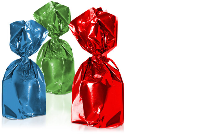 Trois chocolats emballés dans un film twist brillant bleu, vert et rouge.