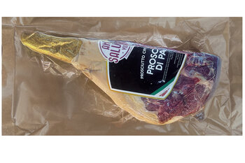 Jambon cru emballé sous vide avec étiquette noire et extrémité de l'os emballée dans du papier doré