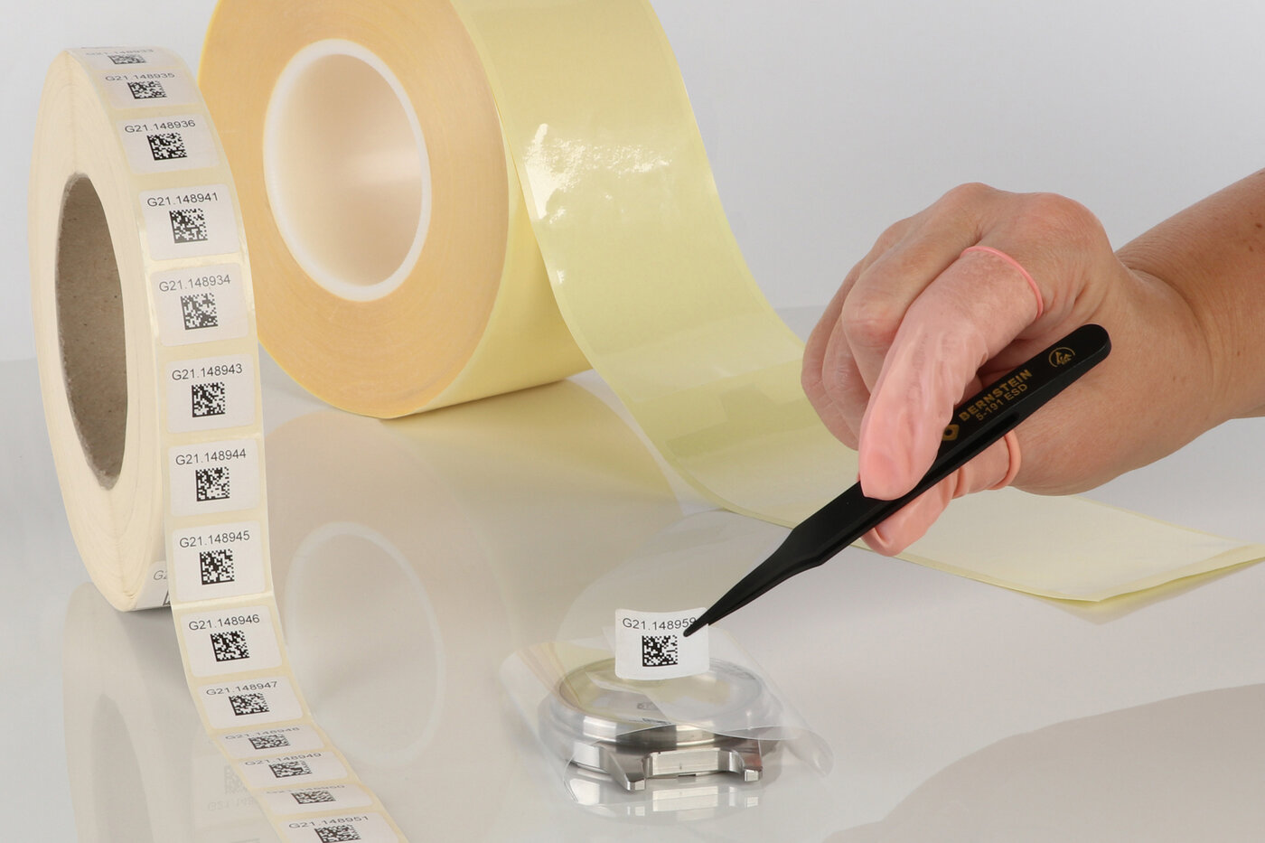Une étiquette avec un code QR est collée sur un film de protection à l'aide d'une pincette en guise de fermeture. 