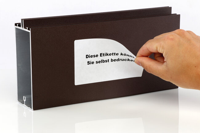 Etikette mit thermotransfer oder thermodirekt bedruckbar wird auf ein Metallstück aufgeklebt. 