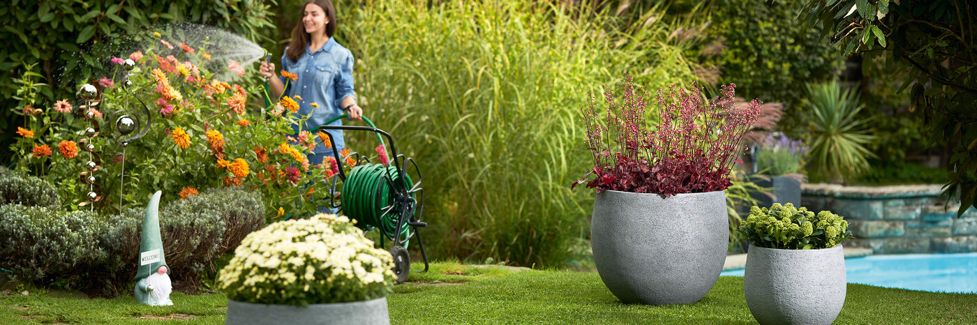 Pots à plantes ronds gris de différentes tailles dans le jardin