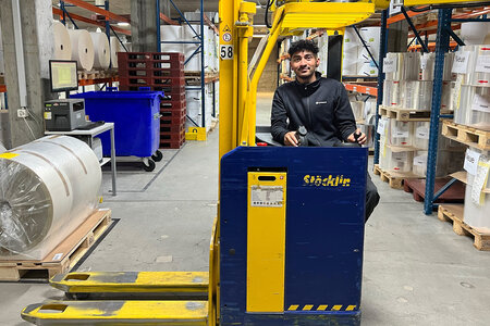 Un apprenti utilise un chariot élévateur