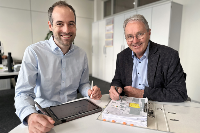 Thomas Hansmann (à droite) et Pascal Graf assis à une table devant un plan d'ensemble
