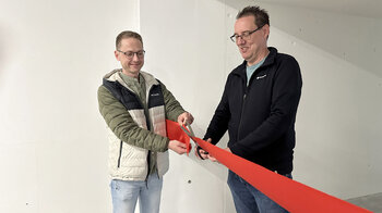 Deux collaborateurs coupent le ruban rouge symbolique. 