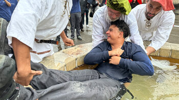 Un homme est plongé dans la fontaine lors de la cérémonie du baptême.