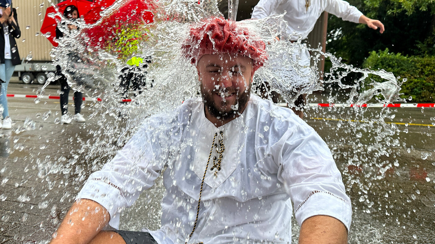 Un homme est arrosé d'eau lors d'une cérémonie de gautschage